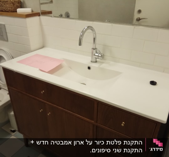 כיור עם ברז בחדר אמבטיה, ארון עץ מתחת